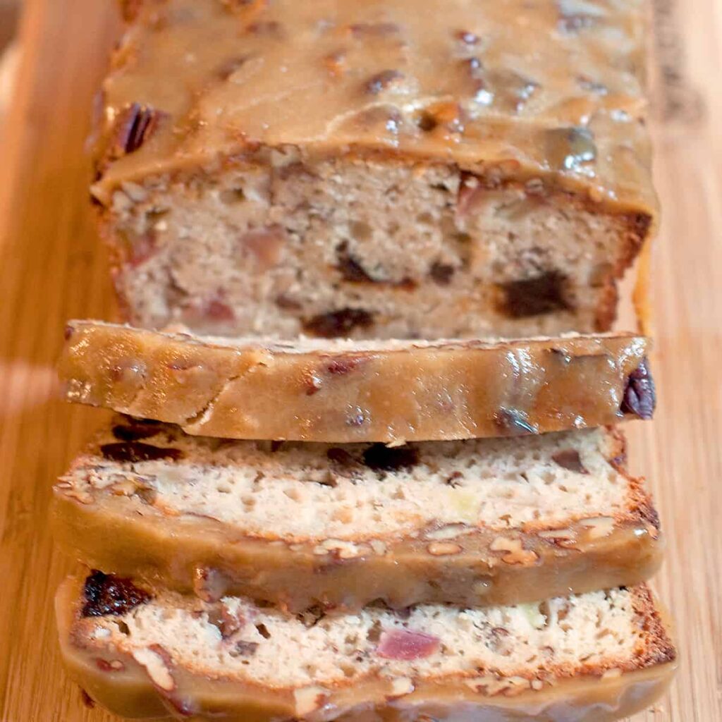 Apple Bread with Praline Topping sliced and presented on a cutting board.