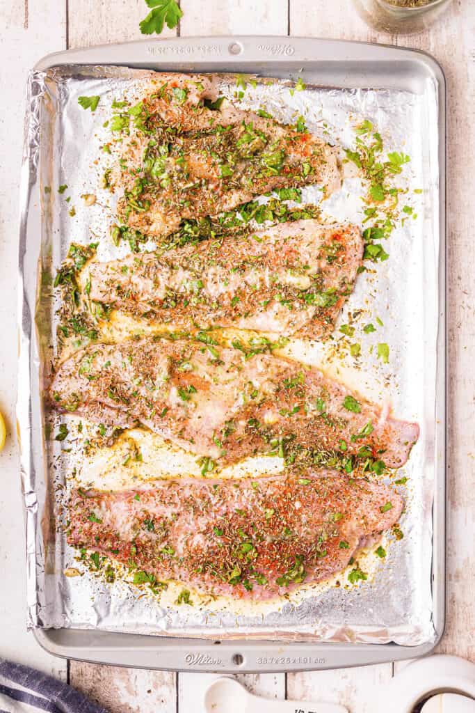 Fish fillets with herbs and lemon butter poured over.