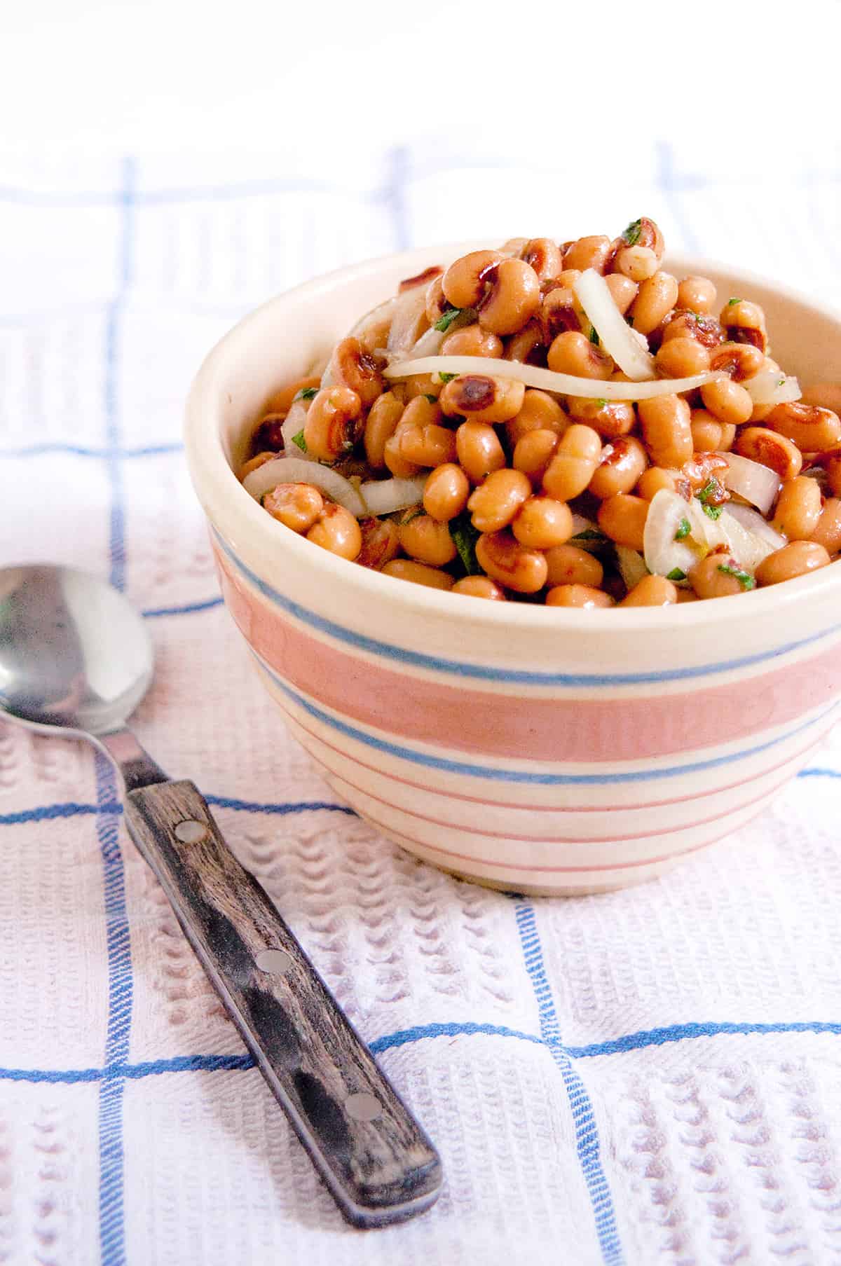 Black Eyed Pea Salad in a vintage serving bowl set on a kitchen towel.