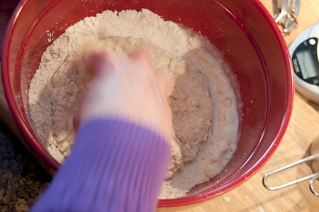 Mixing wet and dry ingredients together by hand in mixing bowl