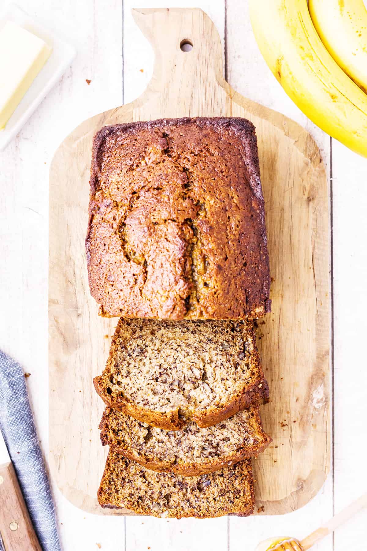 Overhead shot of buttermilk banana nut bread on a wooden serving board.