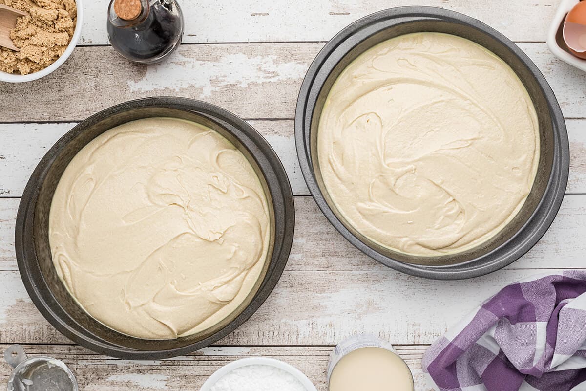 Two cake pans filled with batter.