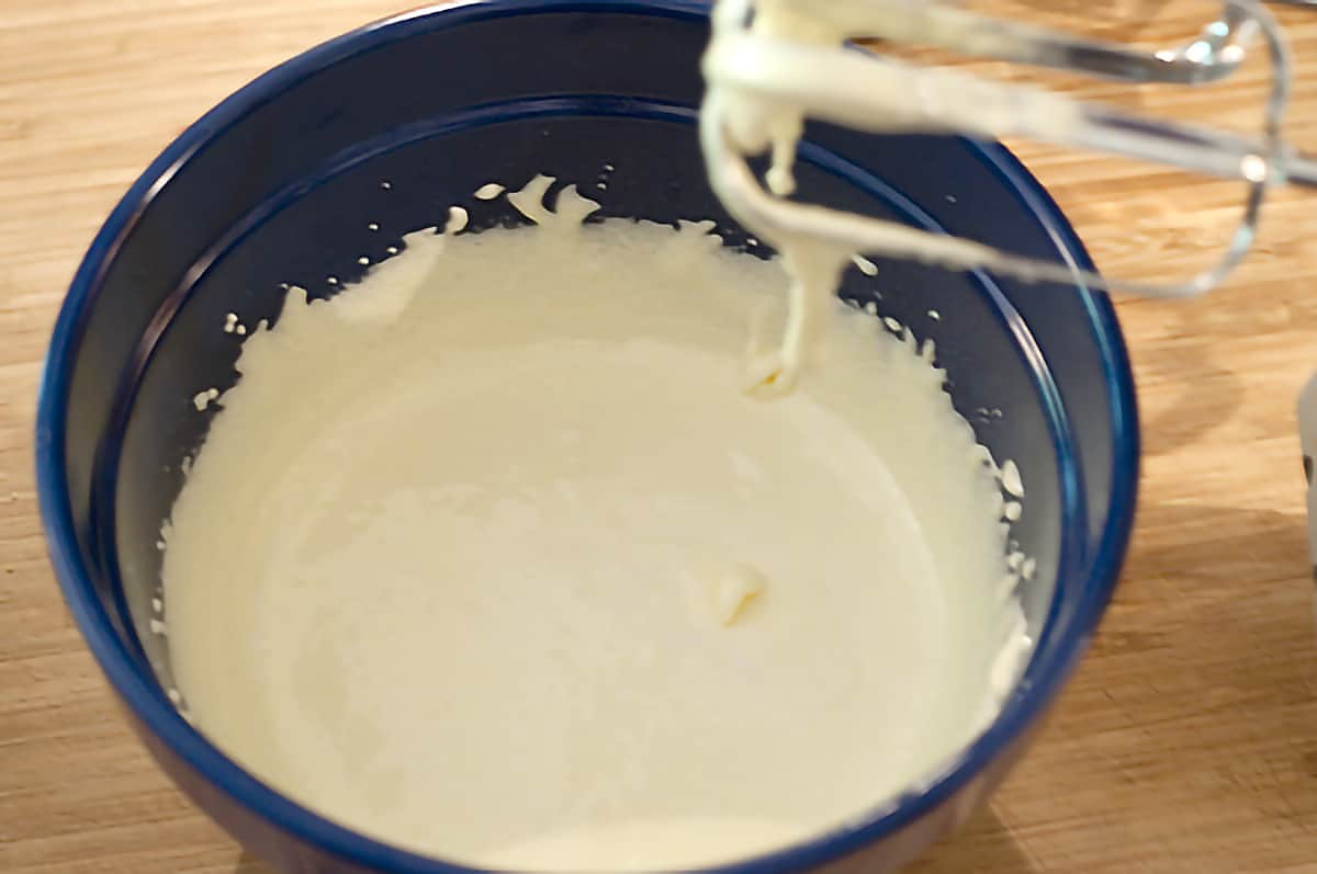 Large mixing bowl containing whipped cream.