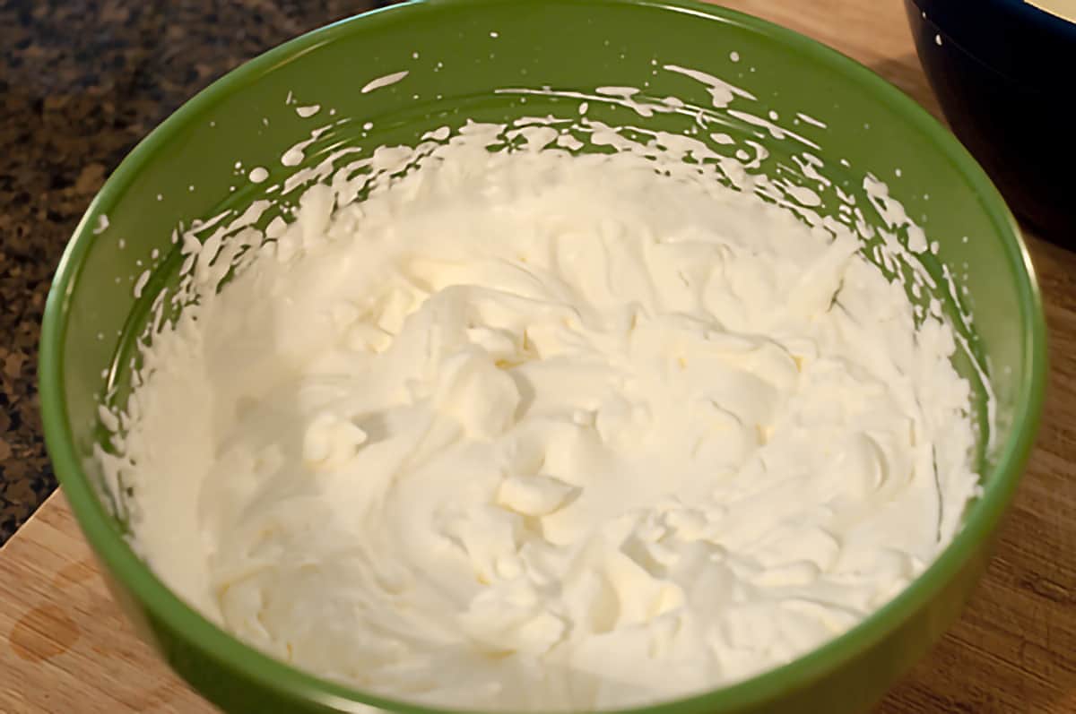 Large mixing bowl containing whipped cream.