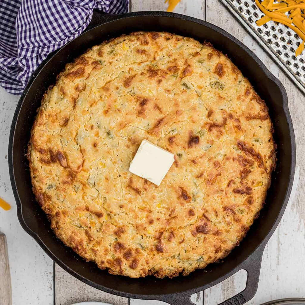 Finished skillet of cornbread with butter on top.