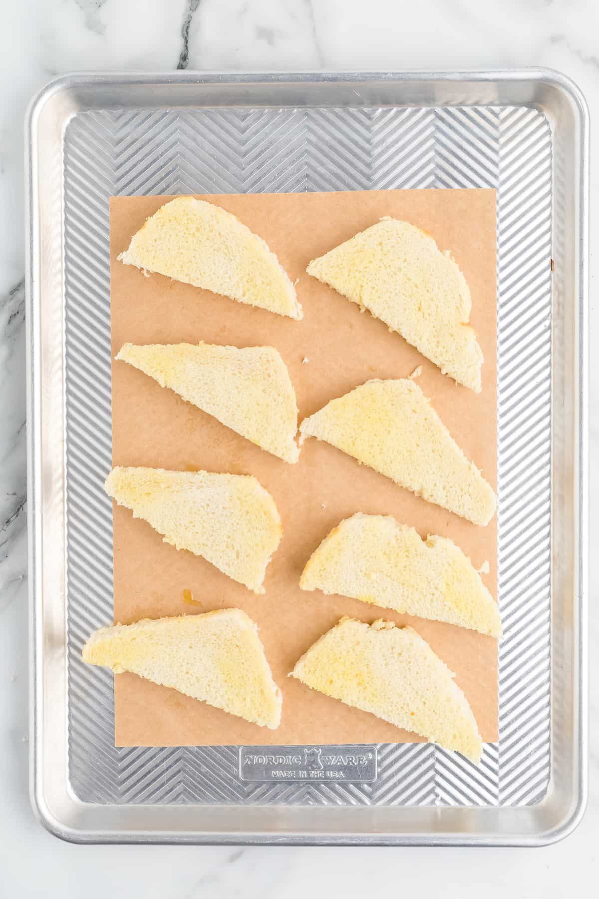 Bread cut into triangles on a wooden board.