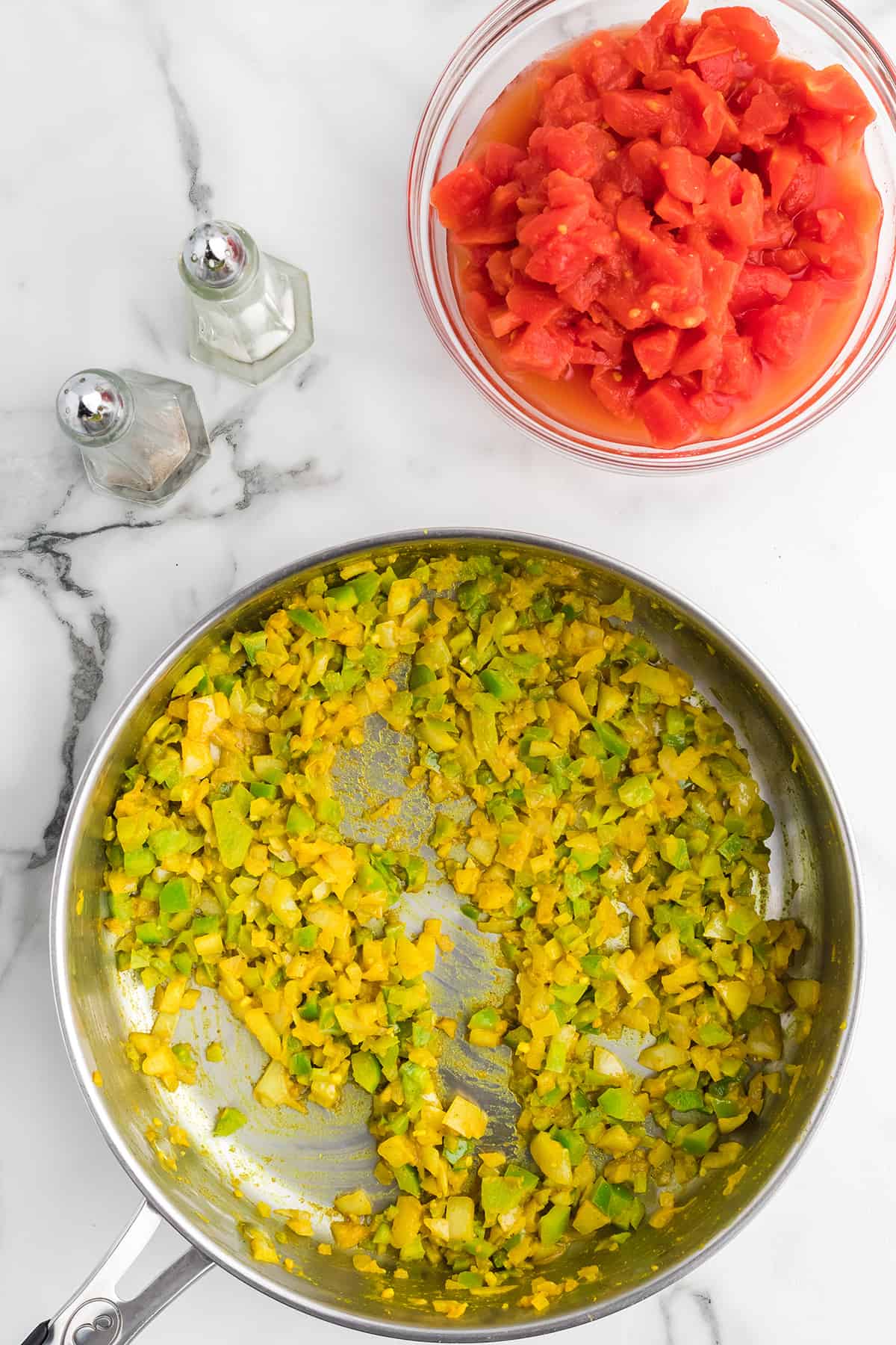 Sauteed vegetables and curry powder in a skillet.