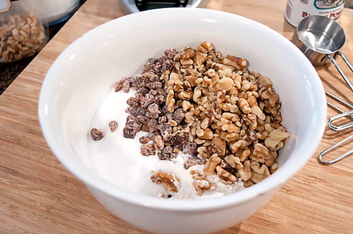 Mixing bowl containing flour, sugar, baking powder, dates, salt, and nuts for the recipe.