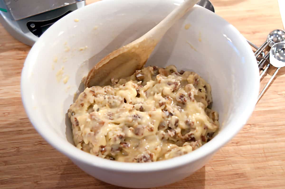 Flour, sugar, baking powder, dates, salt, and nuts with eggs added and stirred into the mixture.