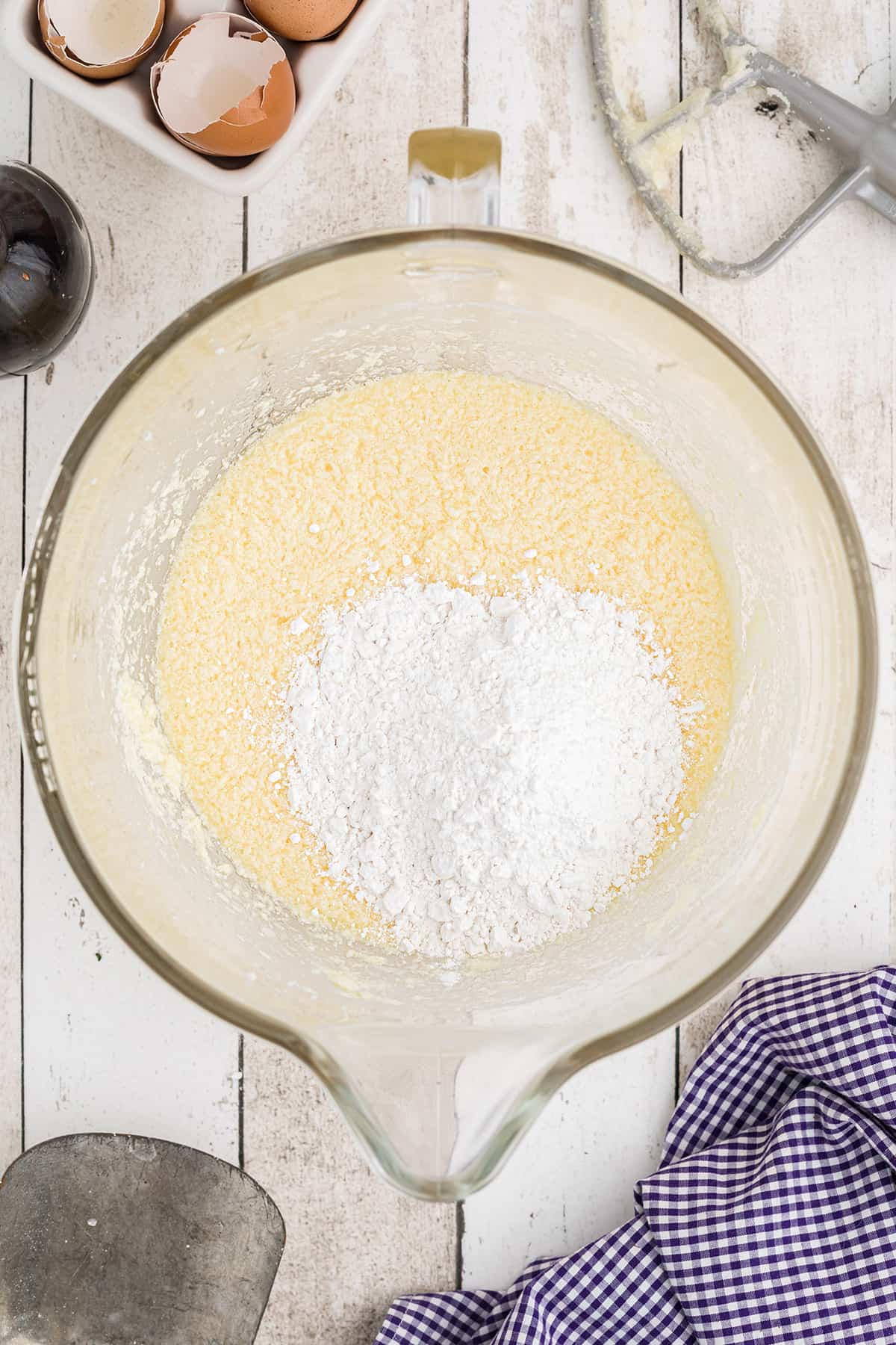 Adding flour to creamed butter and sugar.