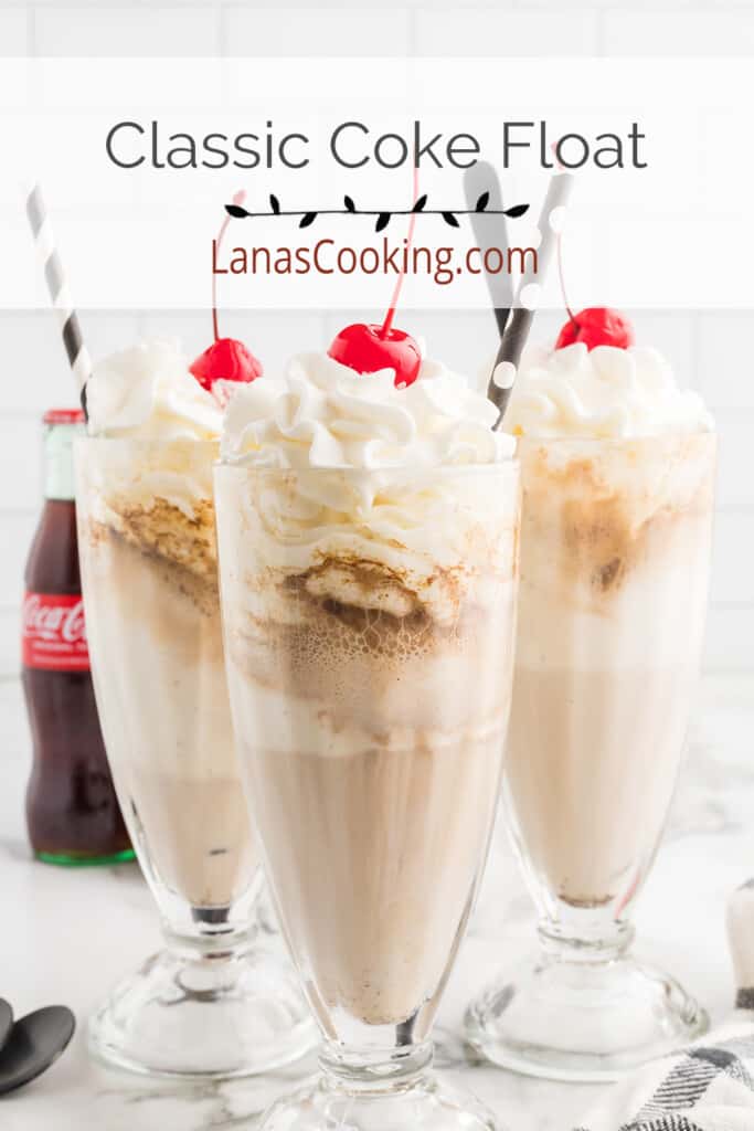 Coke floats in tall glasses with whipped cream and a cherry on top.