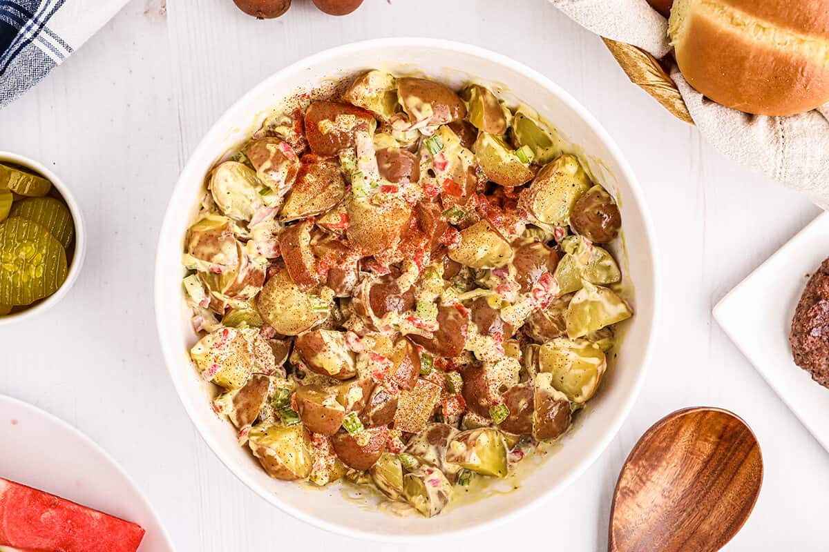 Finished potato salad in a white serving bowl.