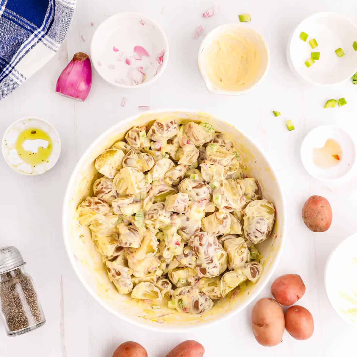 Potato salad ingredients tossed with mayonnaise dressing.