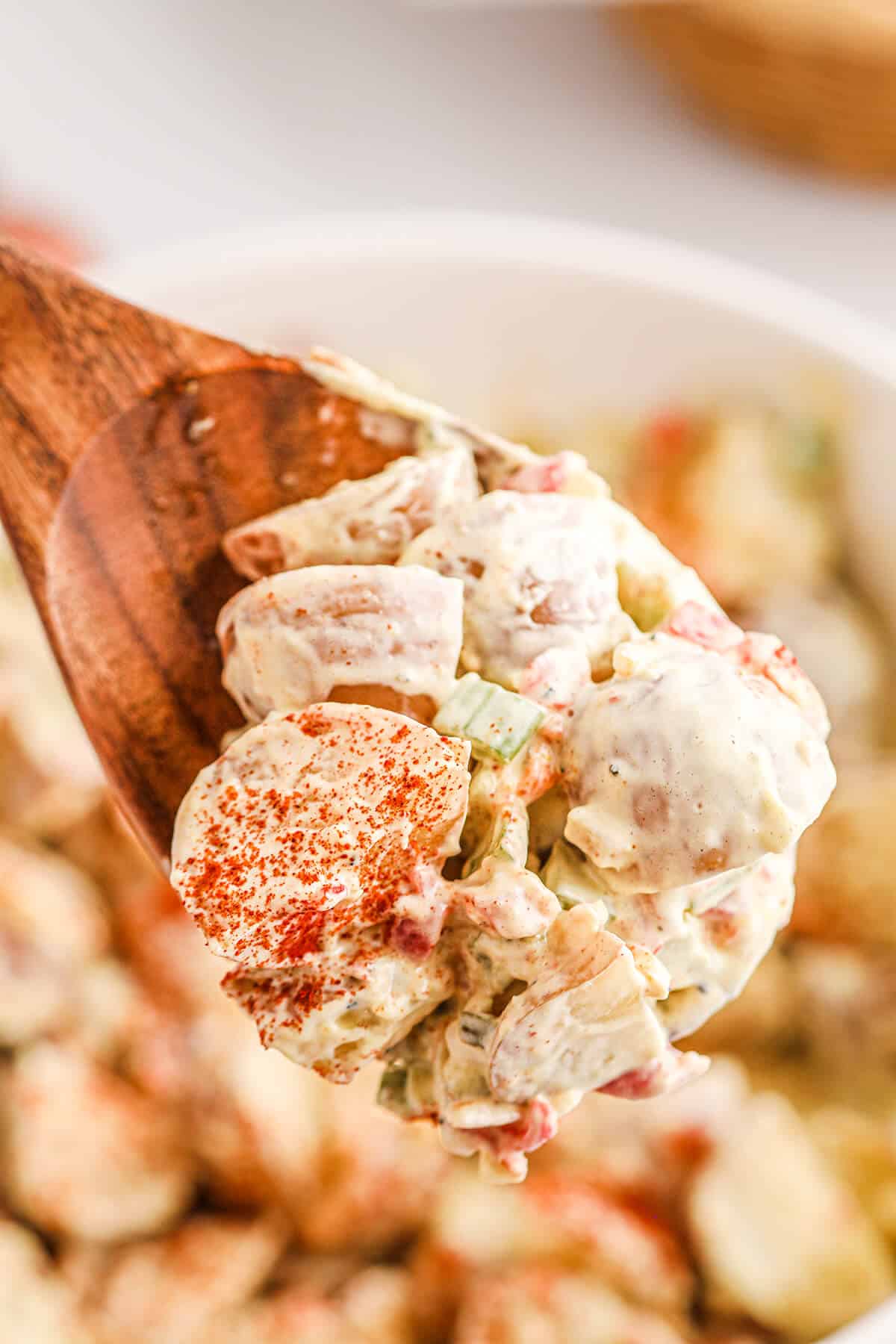 Finished southern potato salad on a wooden spoon.