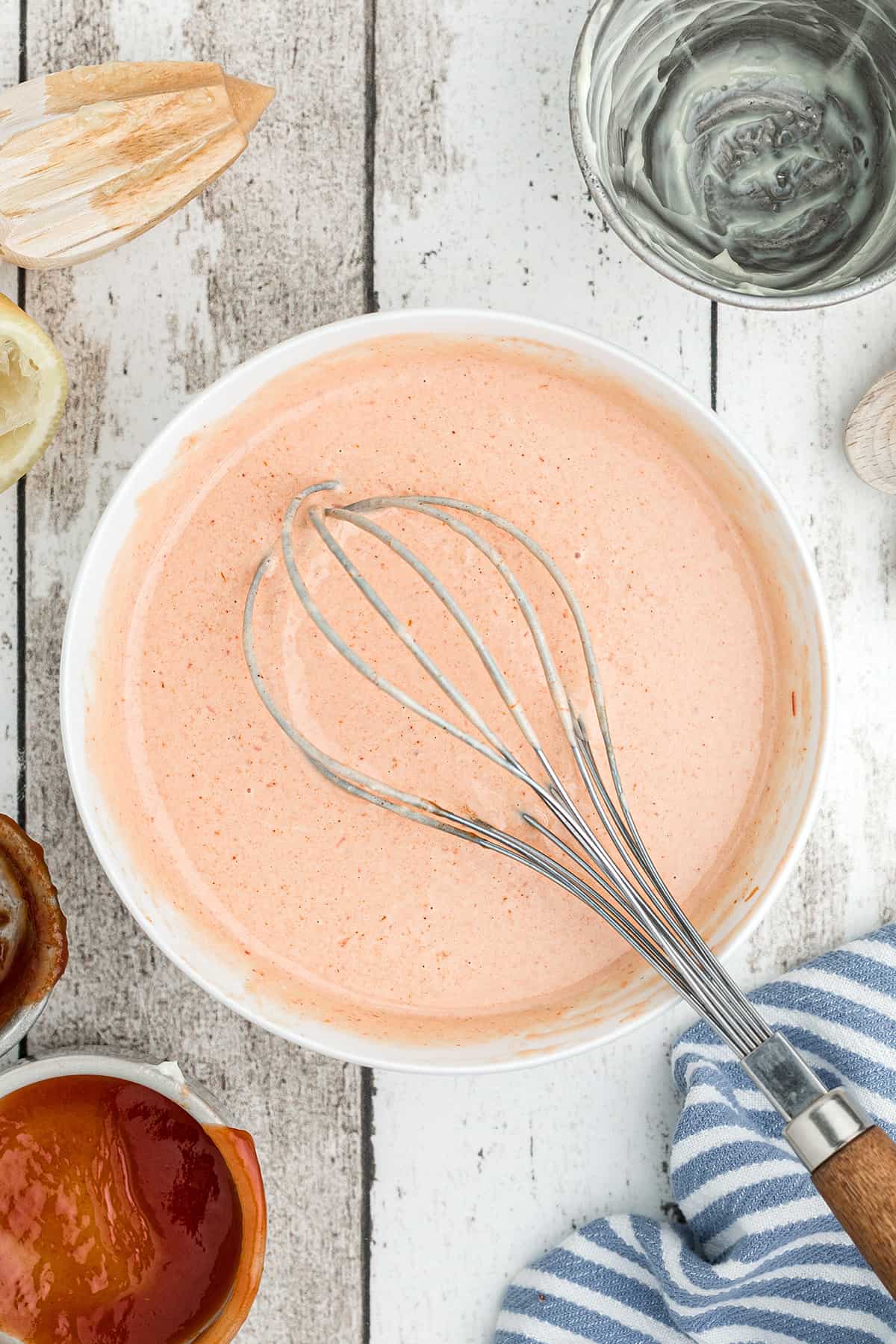 Mixed ingredients and a whisk in a bowl.