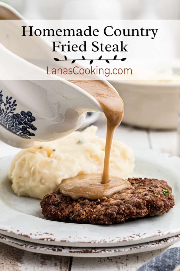 Gravy being poured onto country fried steak on a plate with mashed potatoes.