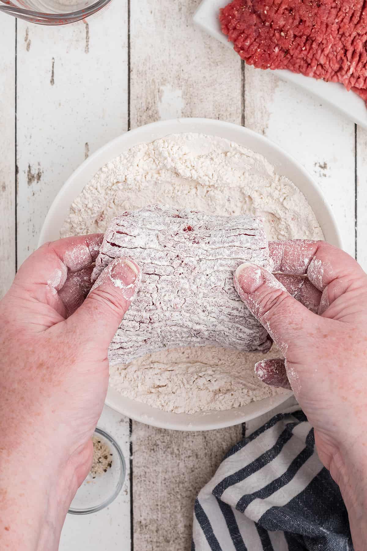 Dreding steak in flour.