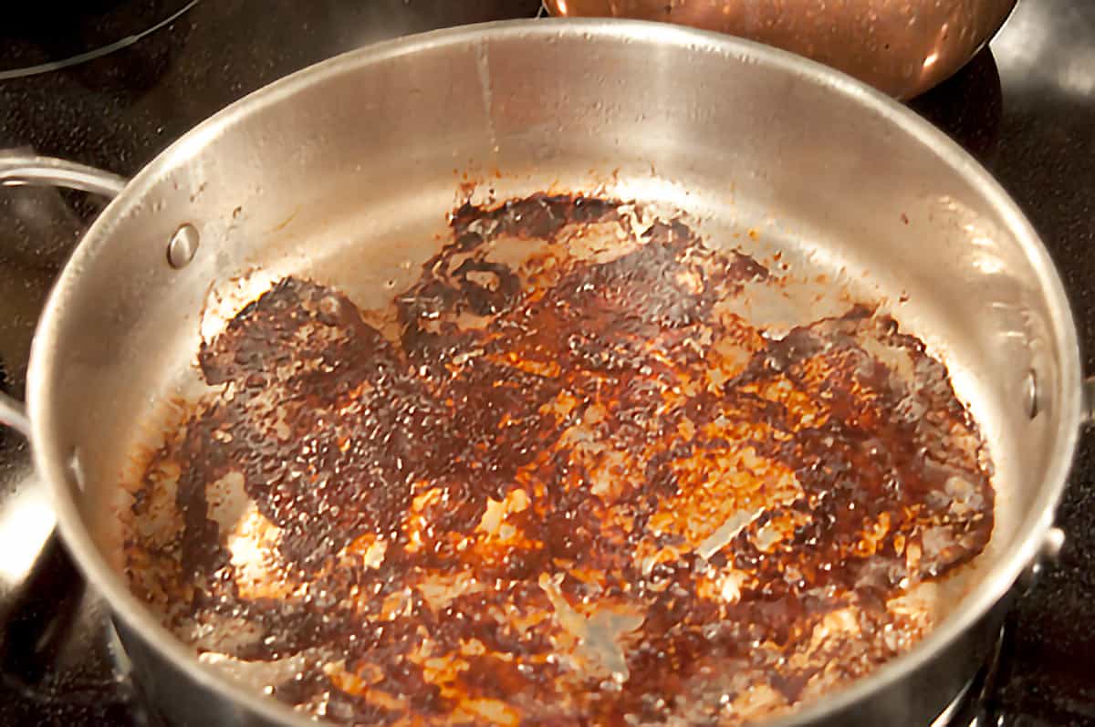 Skillet after cooking ham with residue in the bottom