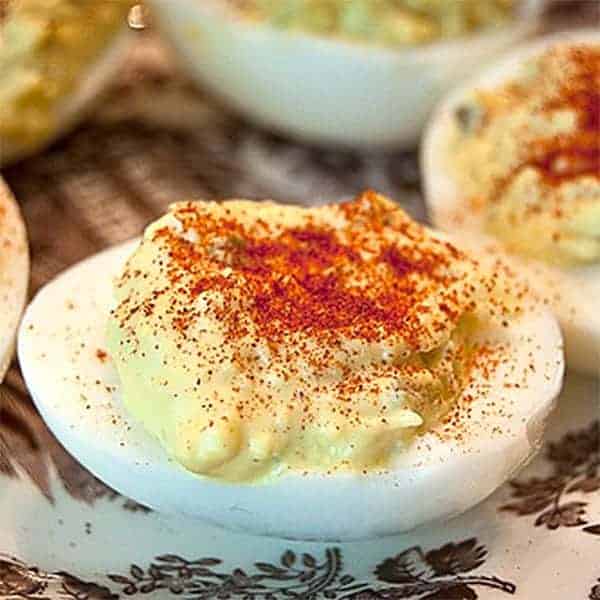 Finished deviled eggs on a decorative platter.