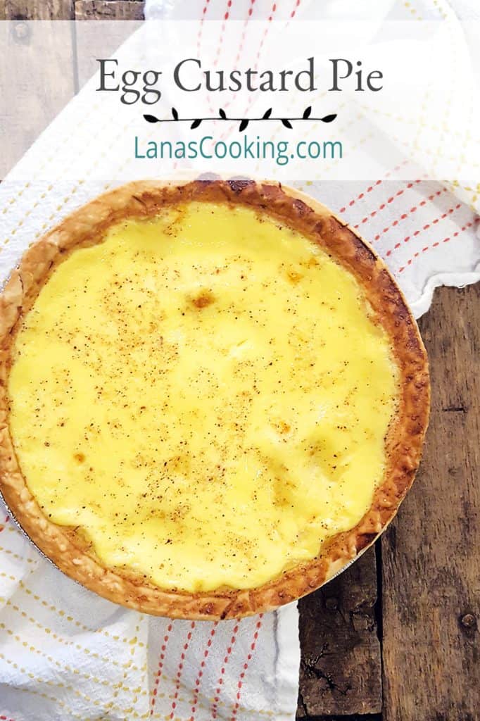 Traditional southern egg custard pie on a serving board with a kitchen towel in the background.