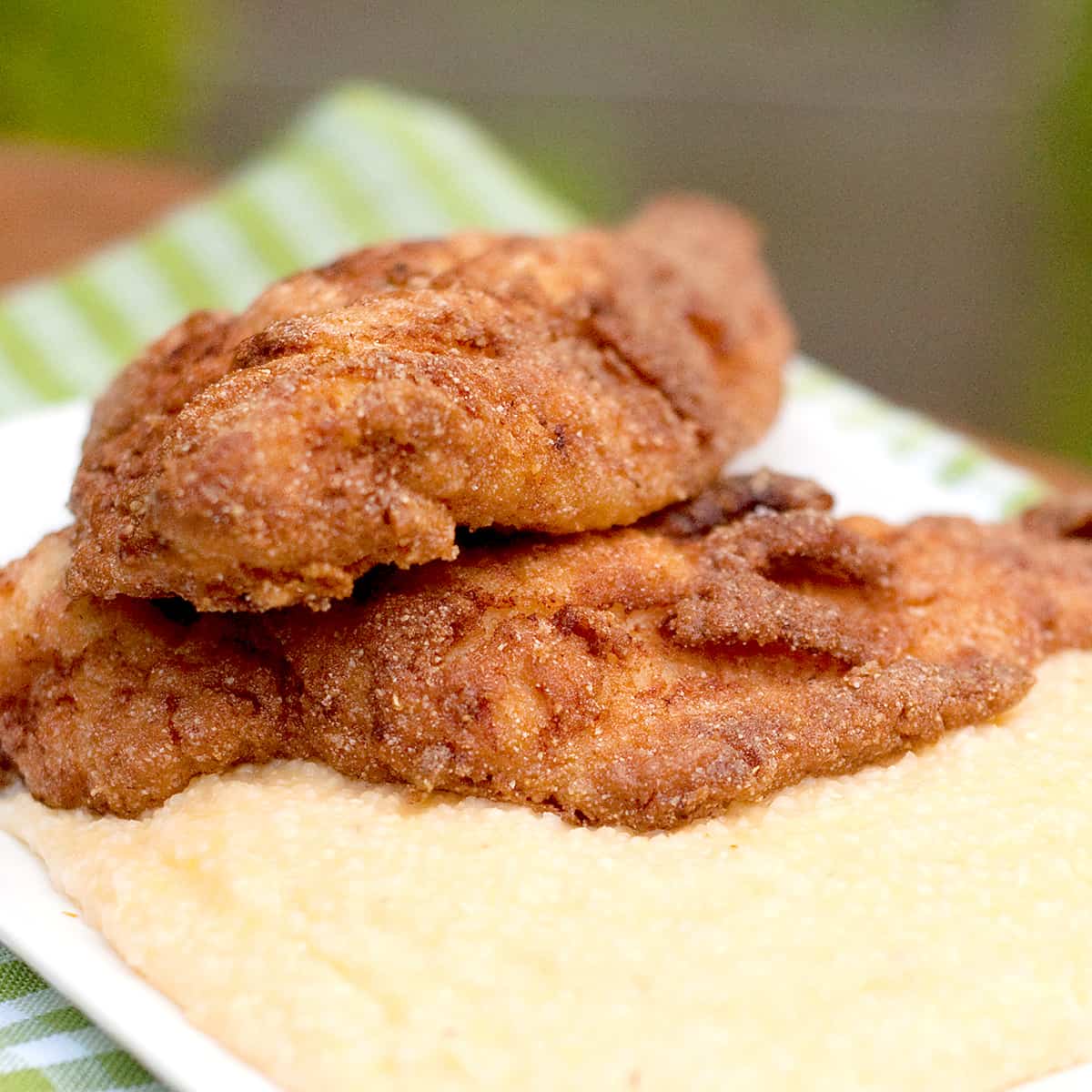 Fried catfish on a platter of cheese grits.