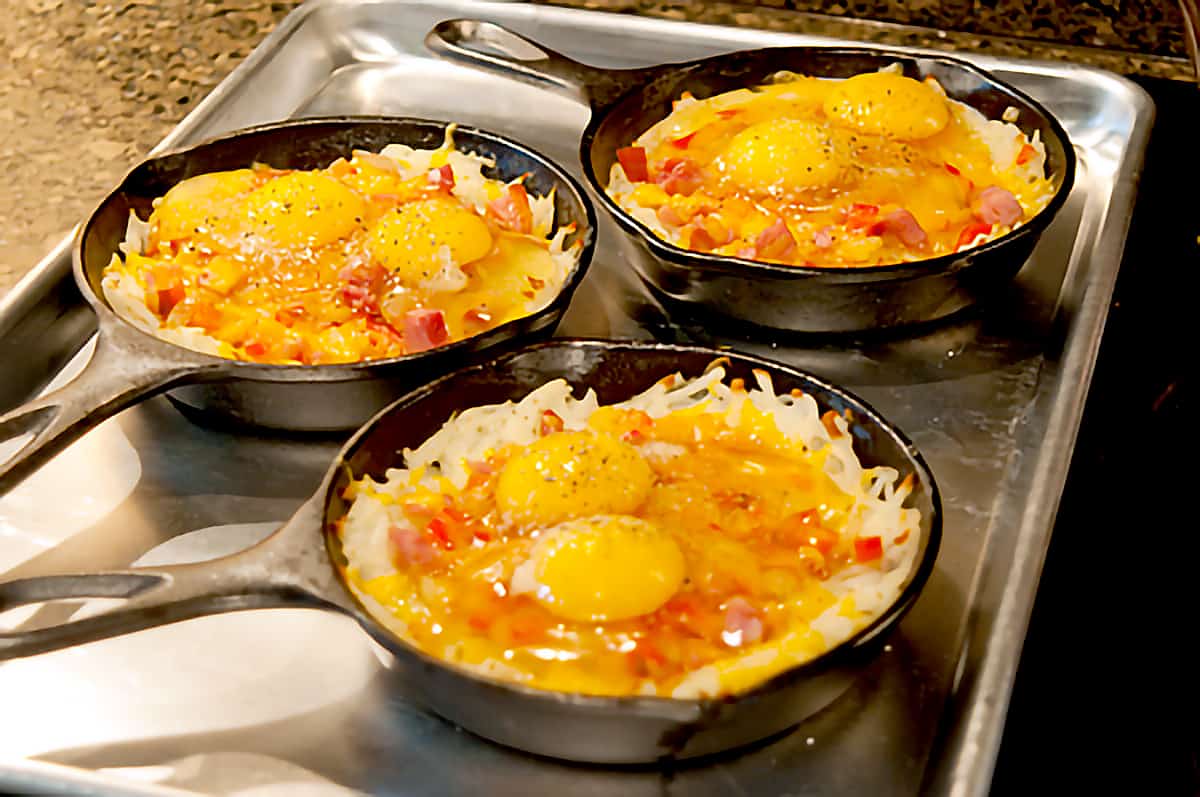 Skillets with eggs added to top of filling mixture.