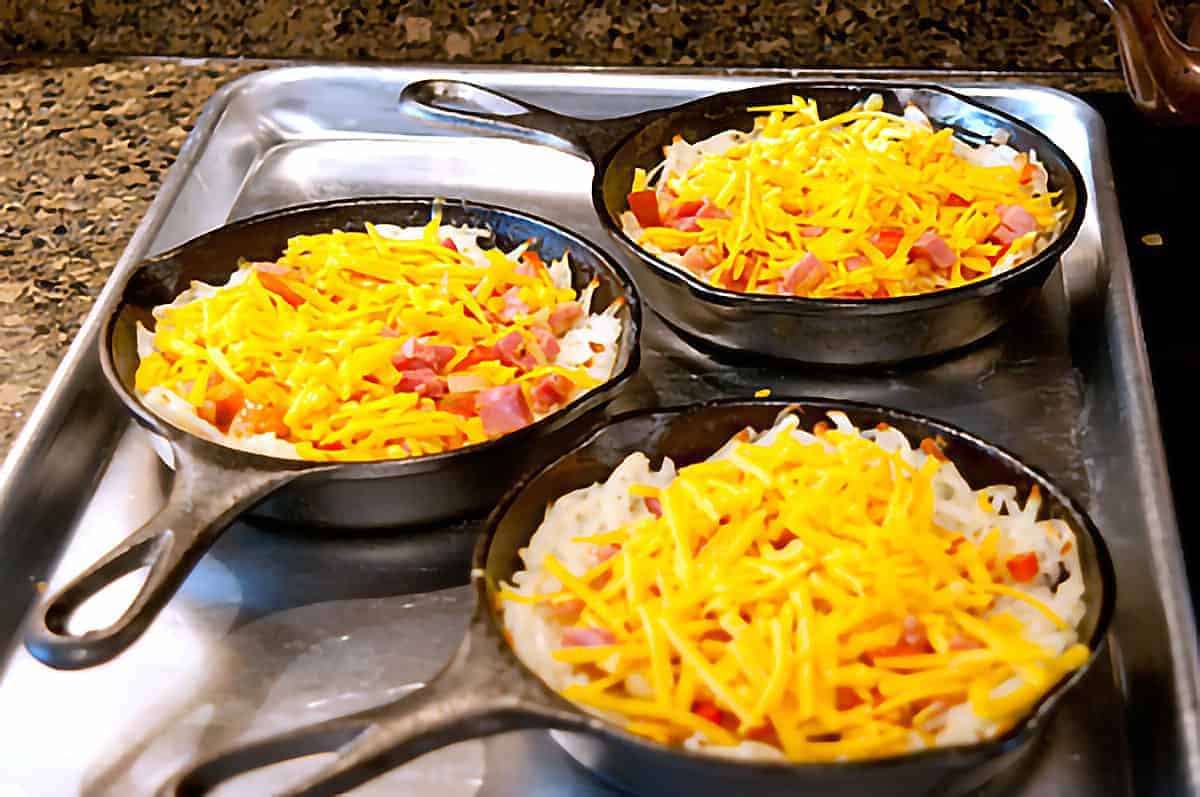 Skillets with filling and cheese added.