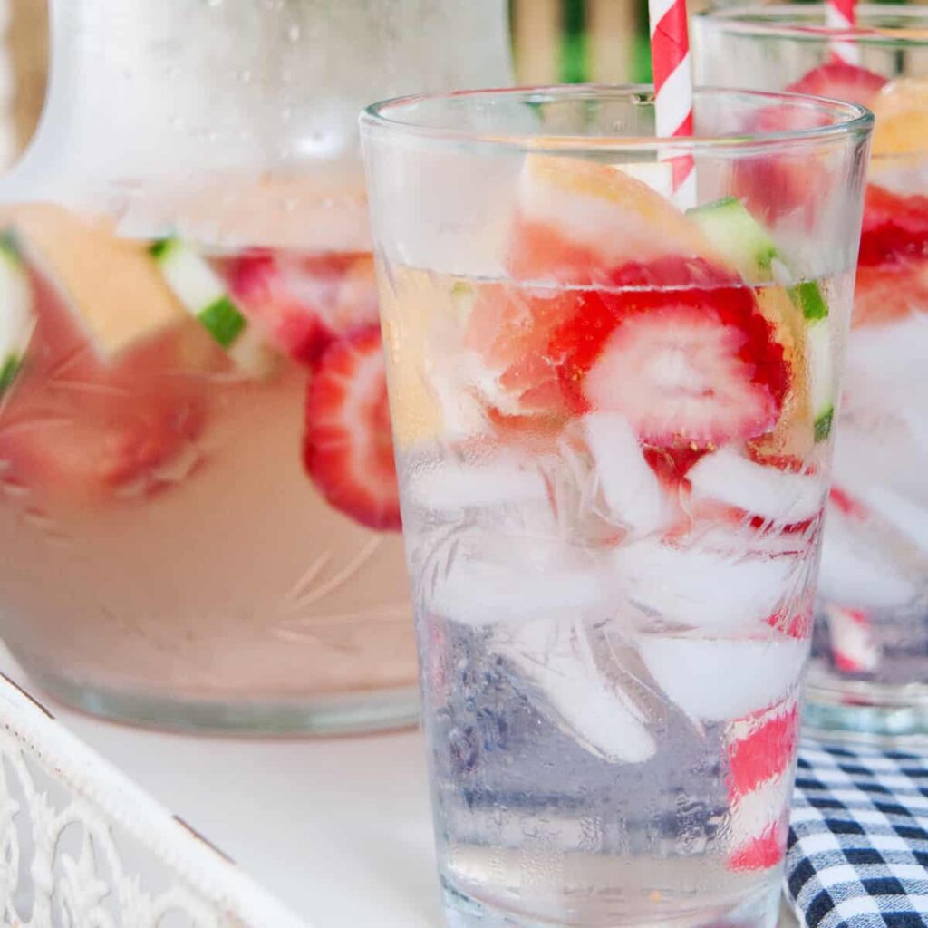 A glass of infused water with strawberries, grapefruit, and cucumbers.