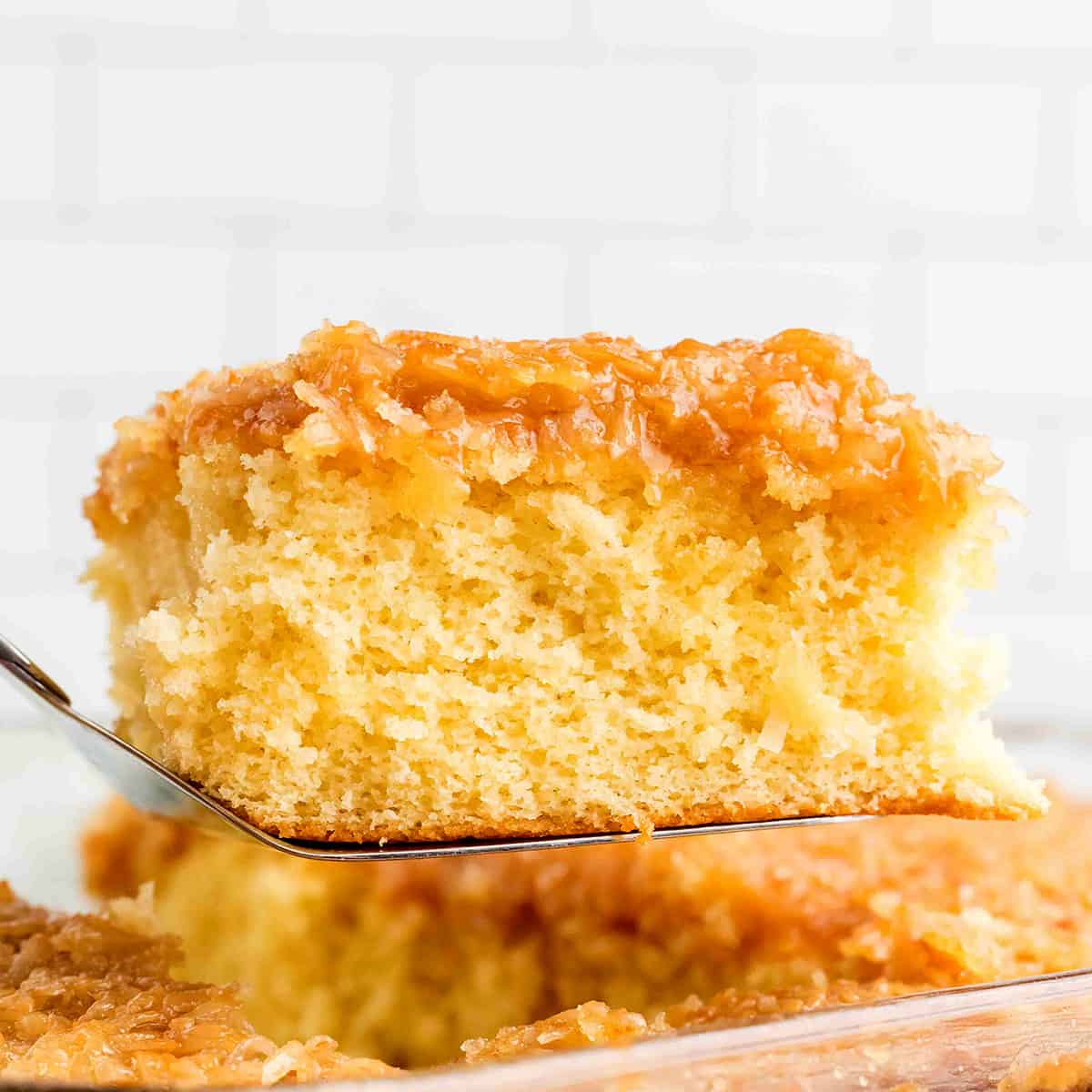 A slice of cake suspended on a spatula.