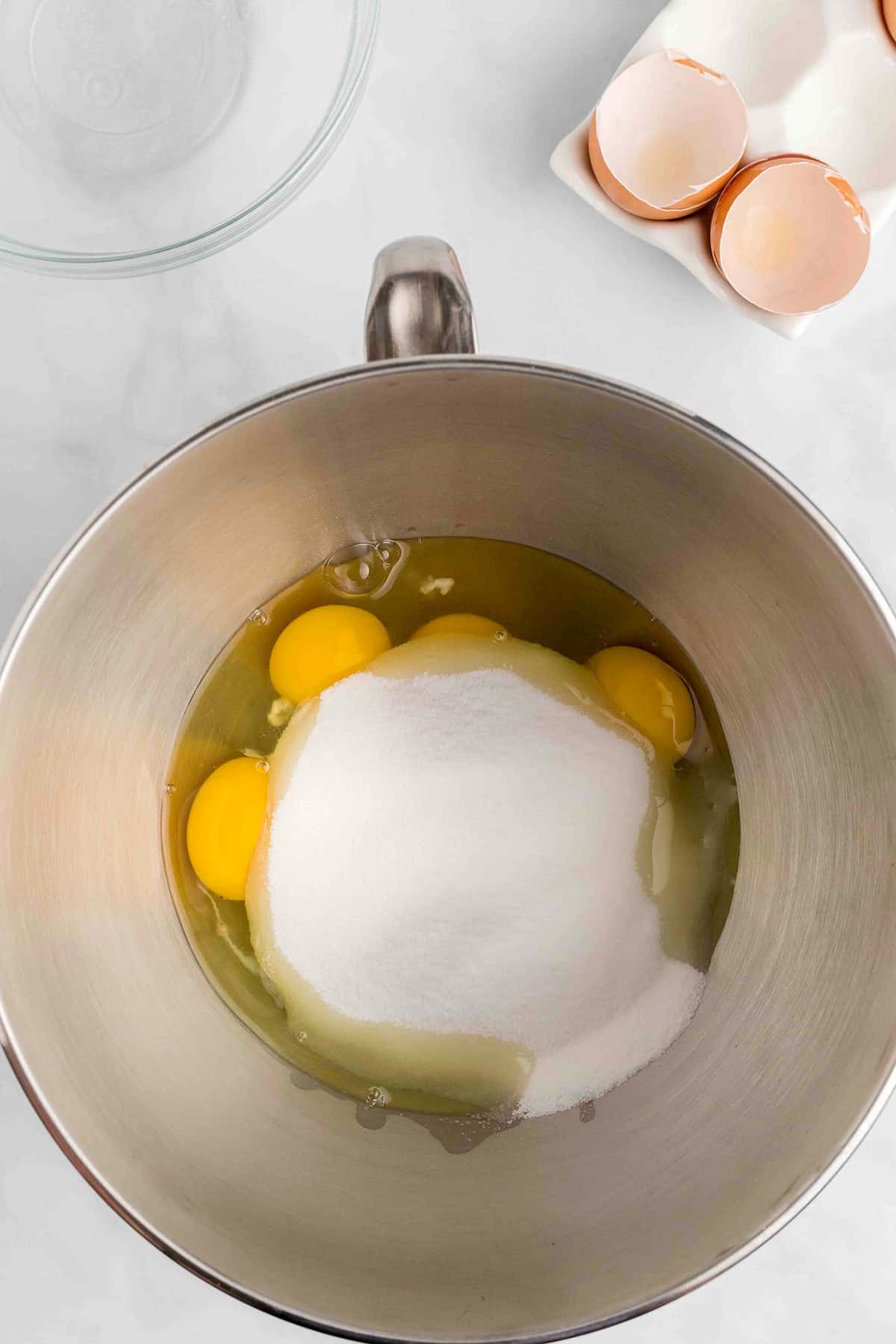 Eggs and sugar in a mixing bowl.