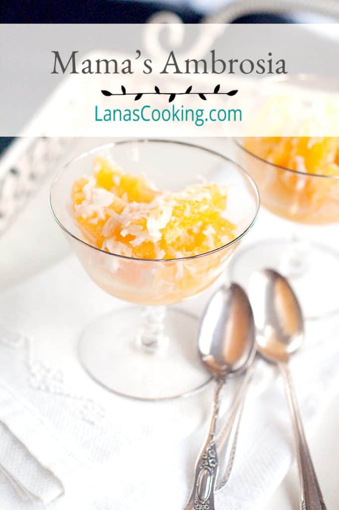 Crystal dish of ambrosia on a serving tray with vintage spoons in the foreground. Text overlay for pinning.