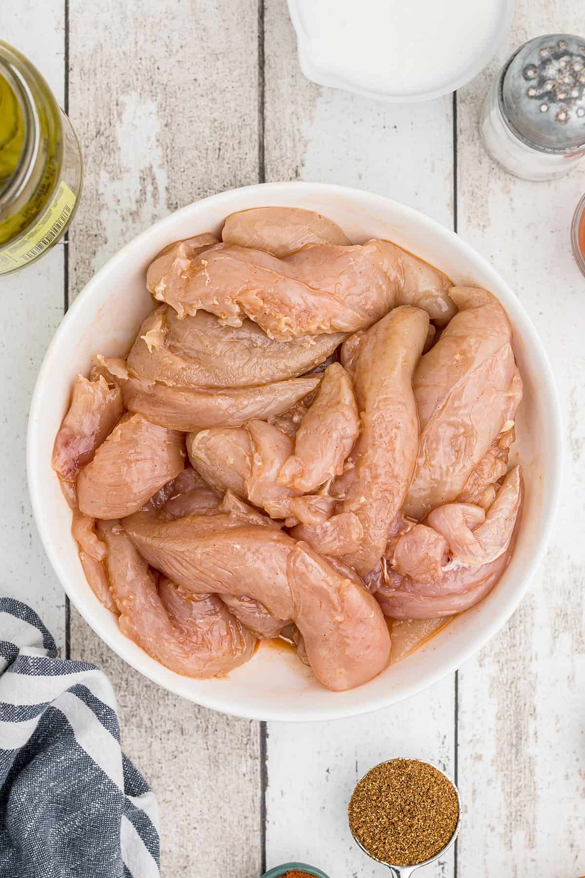 Chicken breast strips in a bowl.