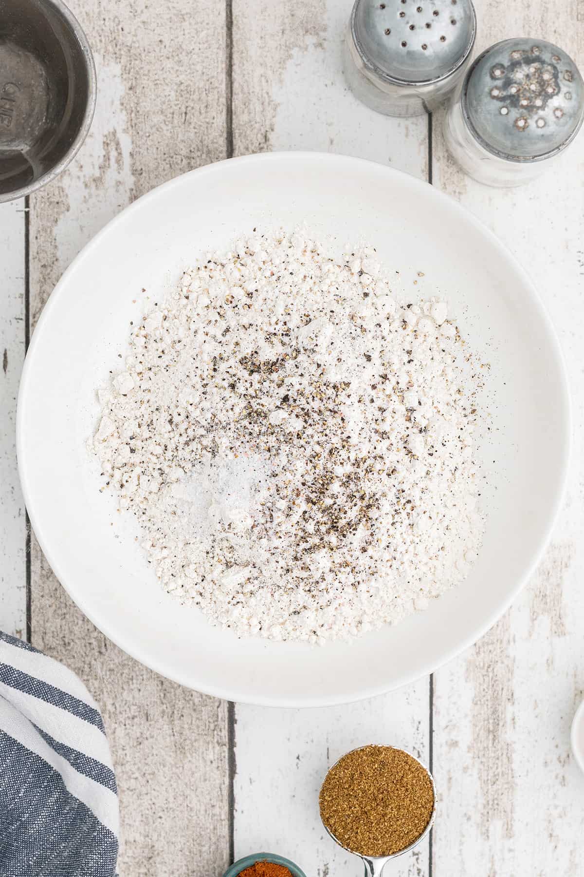 Flour, salt, and pepper in a small bowl.