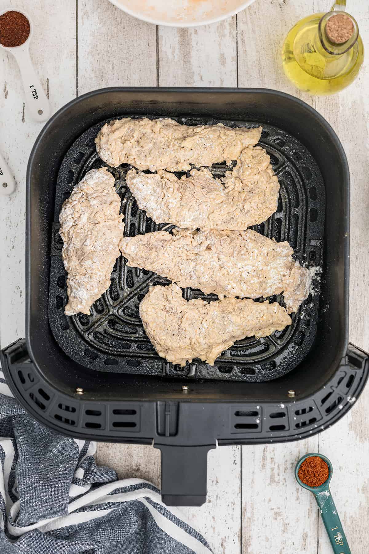 Chicken in air fryer basket.