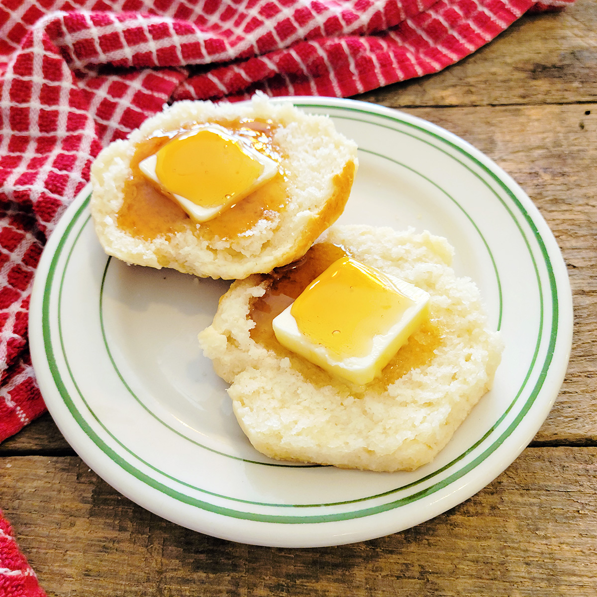 A split biscuit filled with butter and drizzled with honey.