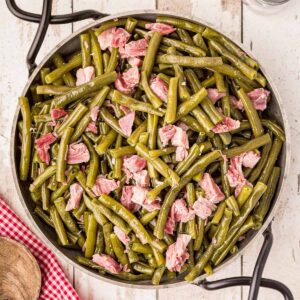 Old Fashioned Southern Style Green Beans with ham hocks in a serving dish on a tabletop.