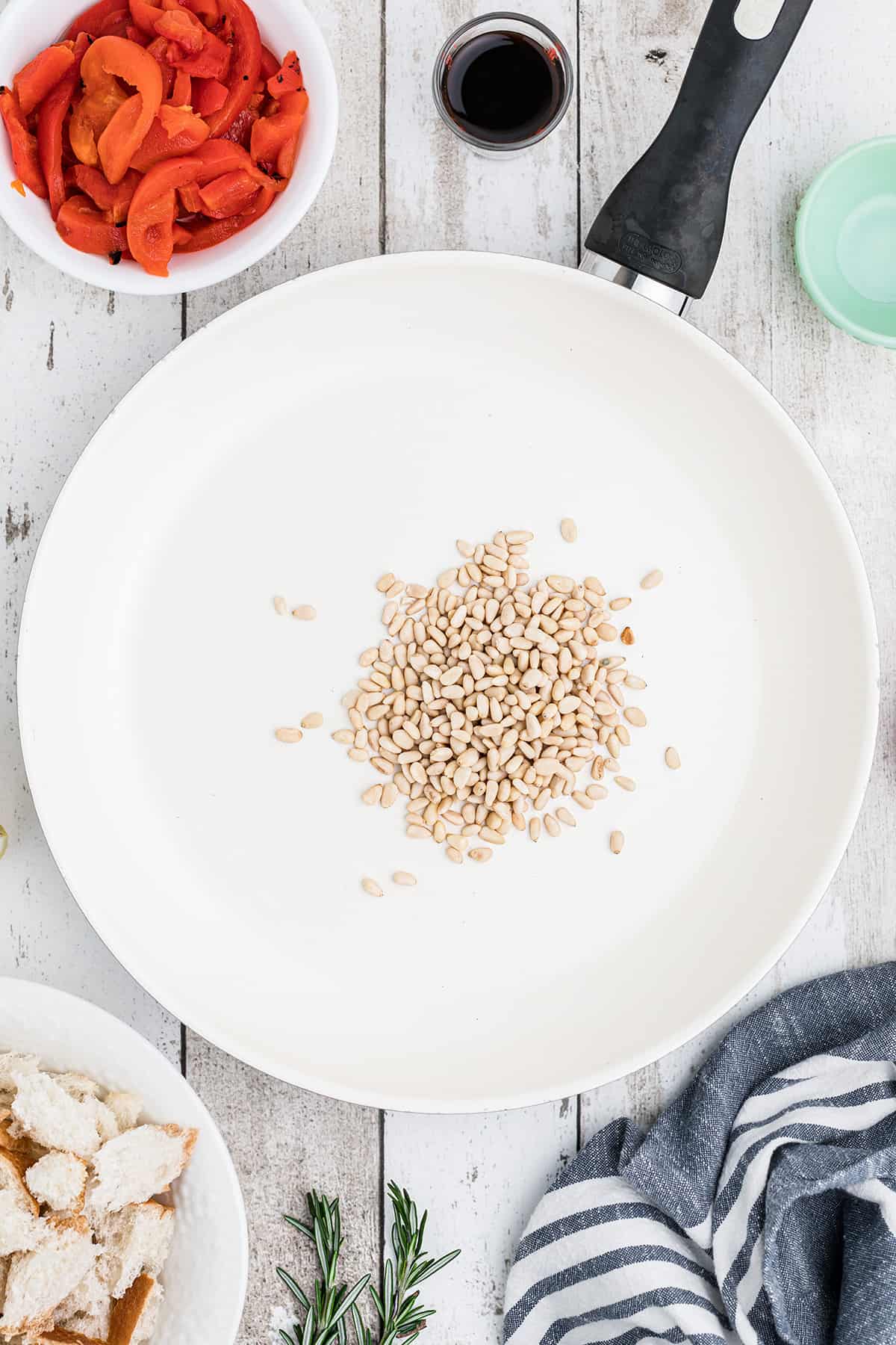 Pine nuts toasting in a skillet.