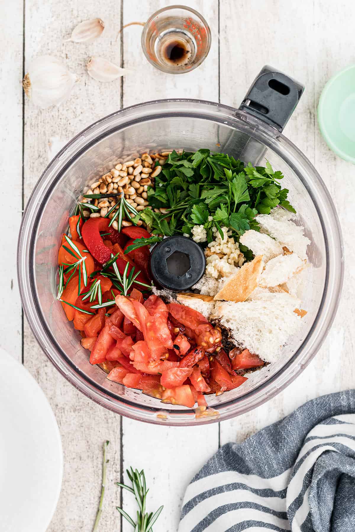 Sauce ingredients added to a food processor bowl.