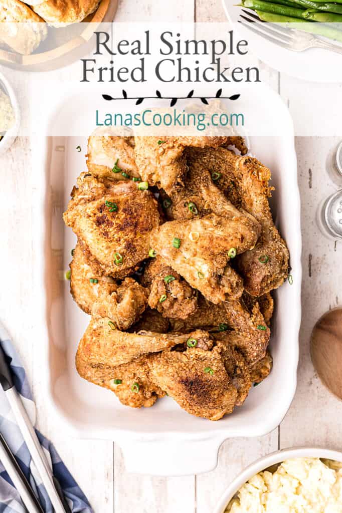 Finished fried chicken on a white serving platter.