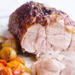 Boneless leg of lamb with vegetables surrounding.