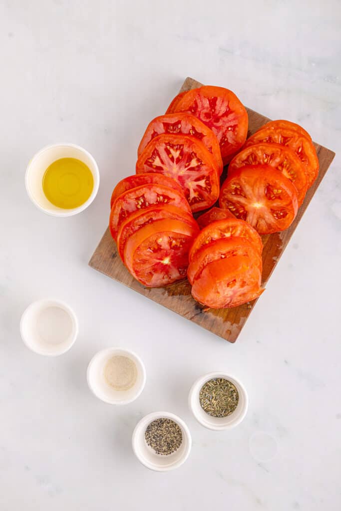 Sliced tomatoes on a wooden board.