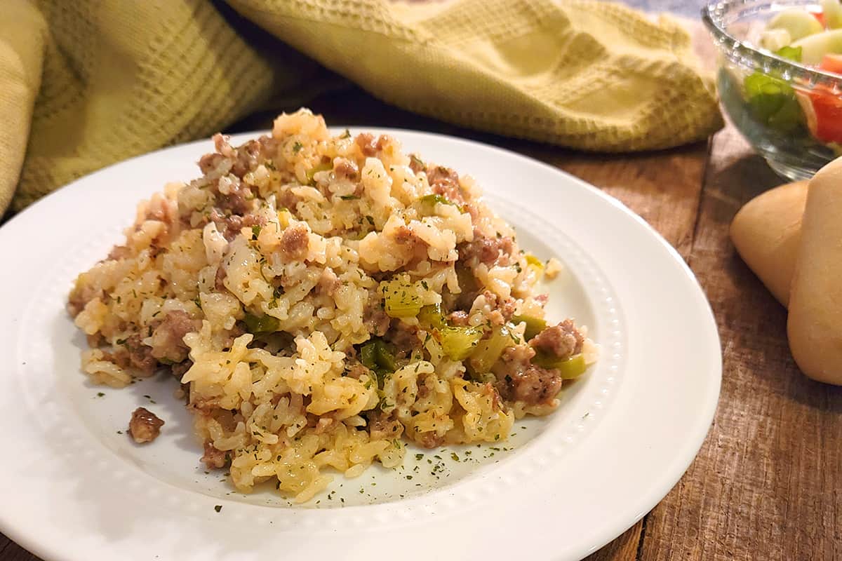 A serving of sausage rice casserole on a white plate.