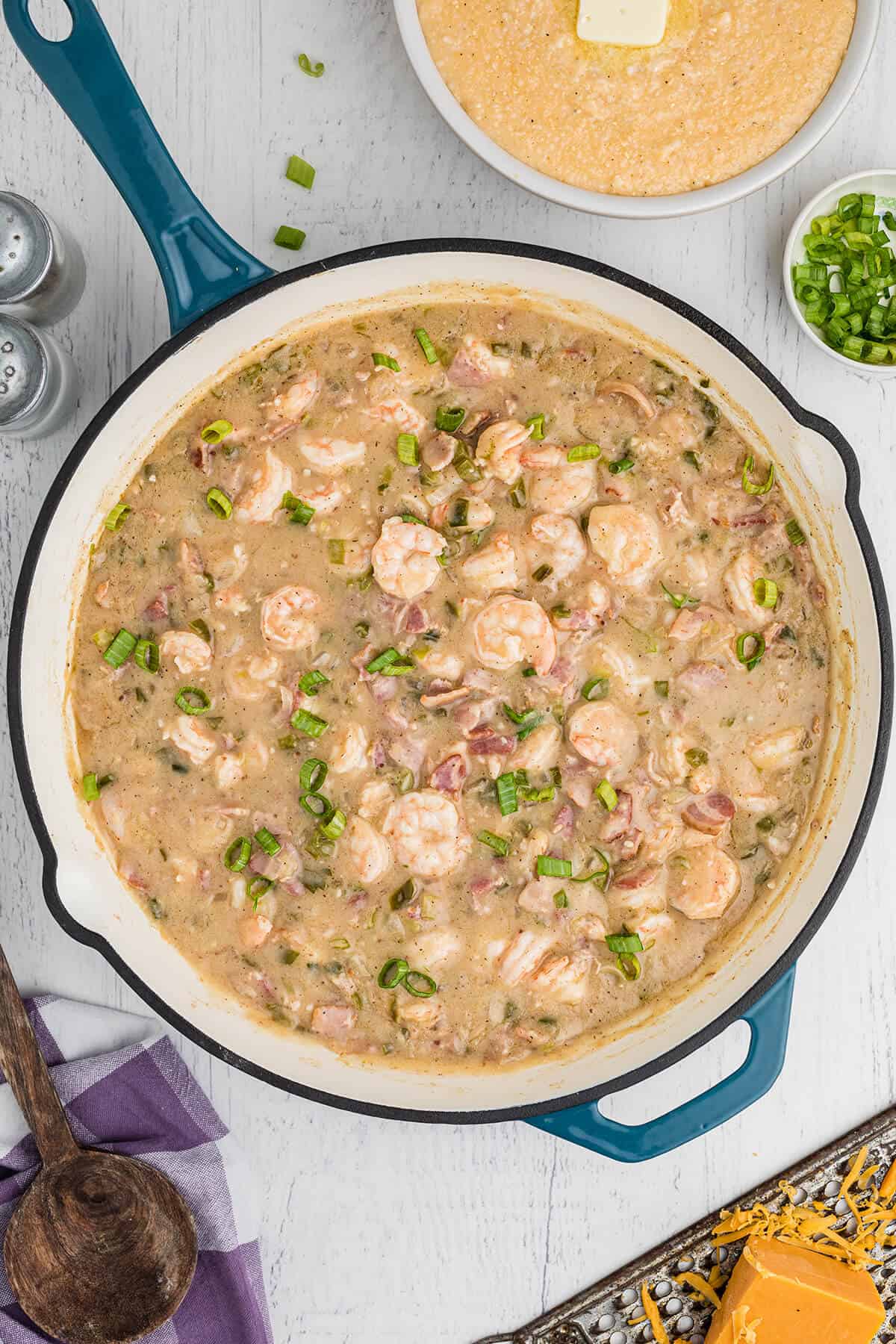 Shrimp stirred into the sauce in a skillet.