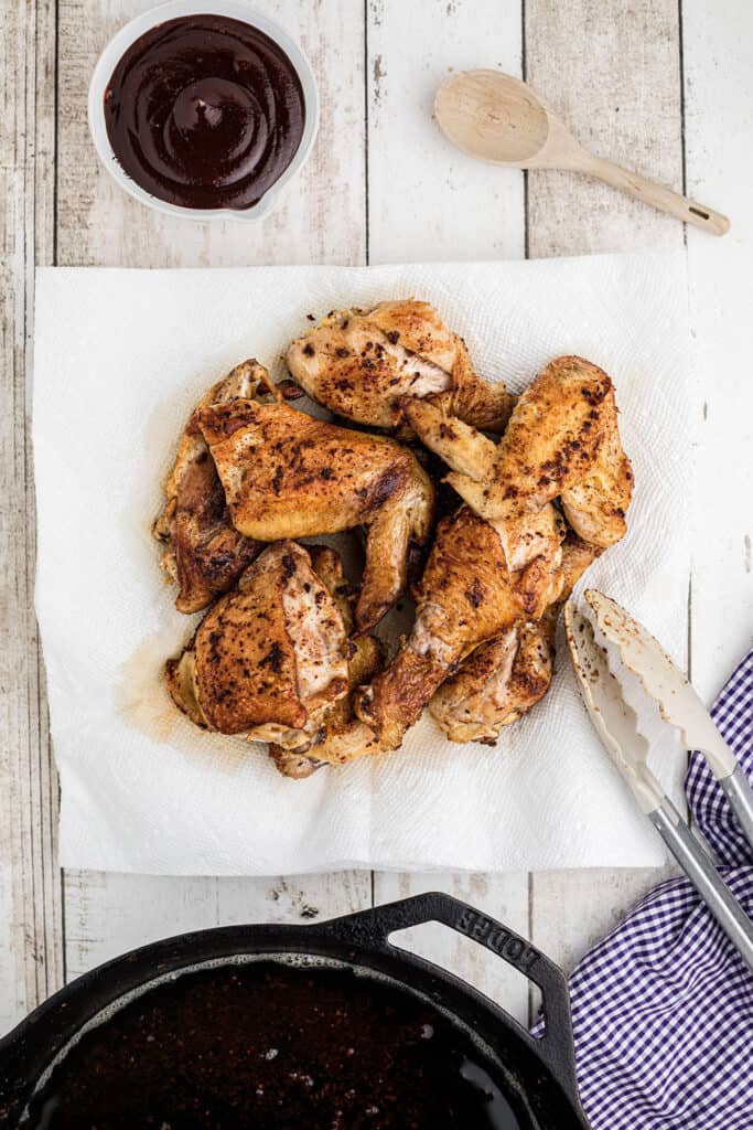 Browned chicken draining on paper towels.