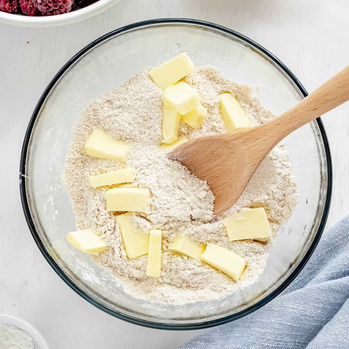 Butter added to flour mixture in bowl.