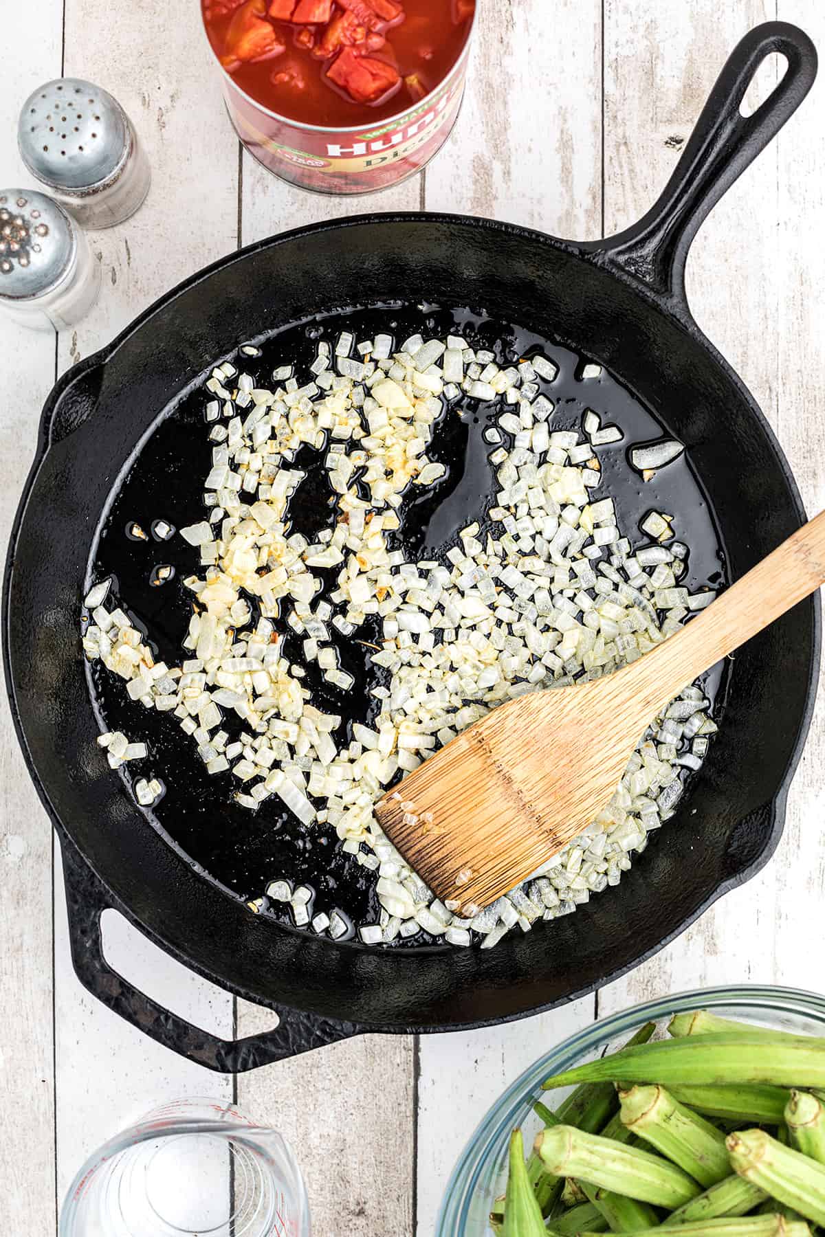 Onions cooking in a cast iron skillet.