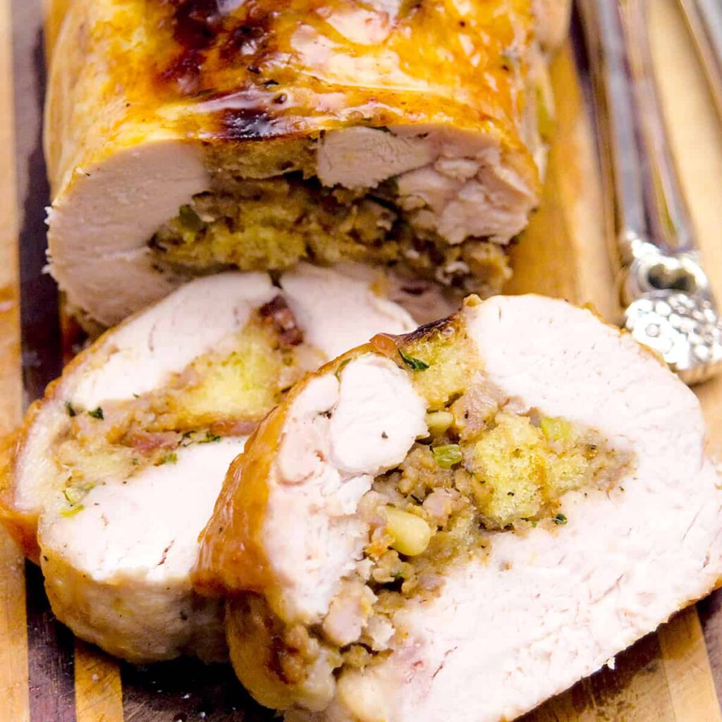 Sliced stuffed turkey breast on a serving tray.