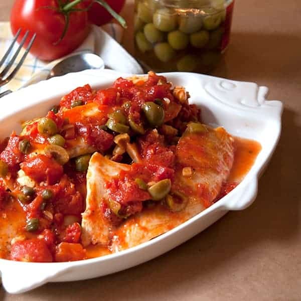 Tilapia Veracruz - tilapia cooked in a flavorful Mediterranean sauce with tomatoes, olives, and capers. https://www.lanascooking.com/tilapia-with-tomato-olive-caper-sauce/