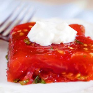 A serving of tomato aspic with a dollop of mayonnaise on top.