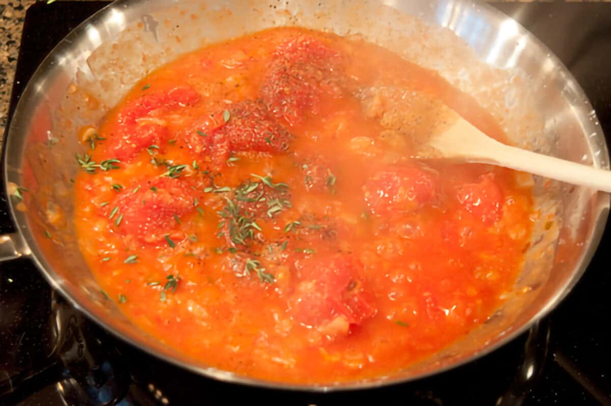 Fresh thyme and seasonings added to the skillet.